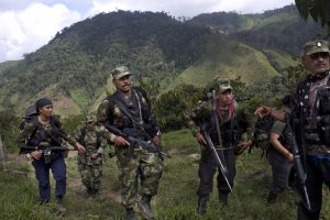 In this Jan. 6, 2016 photo, Juan Pablo, center, a commander of the 36th Front of the Revolutionary Armed Forces of Colombia, or FARC, walks with his comrades in Antioquia state, in the northwest Andes of Colombia. As a commander of the 36th Front, one of the most militarily-active in a half century of warfare, the 41-year-old is capable of reciting verbatim passages from Fidel Castro's speeches even though he's never been to the movies, driven a car or eaten in a restaurant. (AP Photo/Rodrigo Abd)